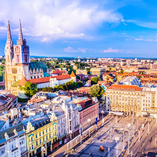 De imposante kathedraal van Zagreb met hoge torens en gotische architectuur tegen een heldere blauwe lucht.