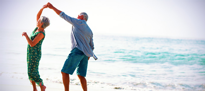 Seniore man aan het wandelen over het strand