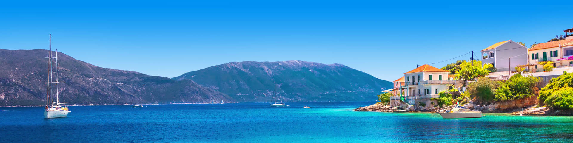 Het helderblauwe zeewater met bergen op de achtergrond tijdens de meivakantie Kreta