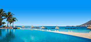 Infinity pool met palmbomen aan de kust van Mauritius, turquoise water en helderblauwe hemel in een tropisch resort.