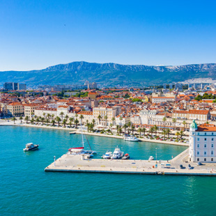 Zicht op het centrum van Split met Romeinse architectuur, gezellige pleinen en palmbomen aan een zonovergoten kustlijn.