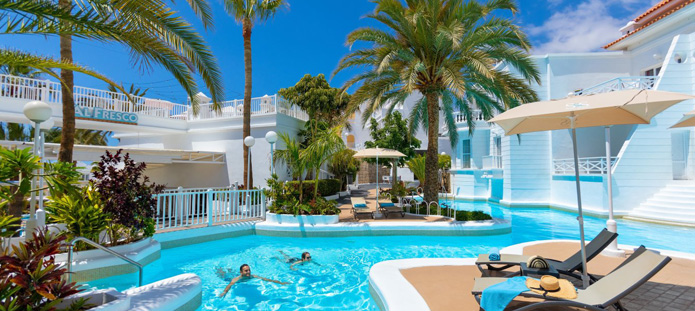 Verfrissend zwembad bij een hotel met palmboom op de achtergrond