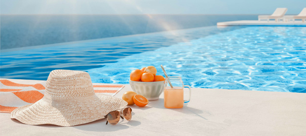Hoed, zonnebril en lekker drankje bij het zwembad op vakantie